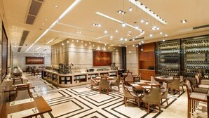 A spacious hotel lobby with a bar area, seating arrangements, and a large screen. - Leeden Jingxi Hotel (Guangzhou)