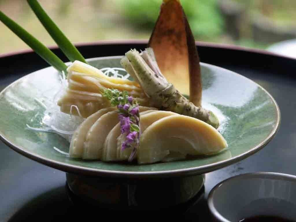 Een bord eten met een houten lepel en stokjes.