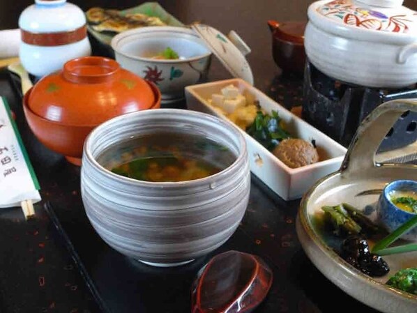 A table with various dishes and bowls, some with lids and others open. - Ryokan Hanareya Ishidaya (Kawazu)