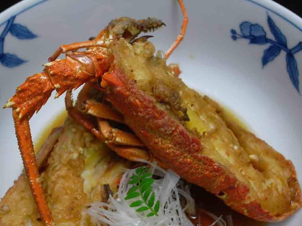 A bowl of fried crab with a decorative floral pattern on the side.