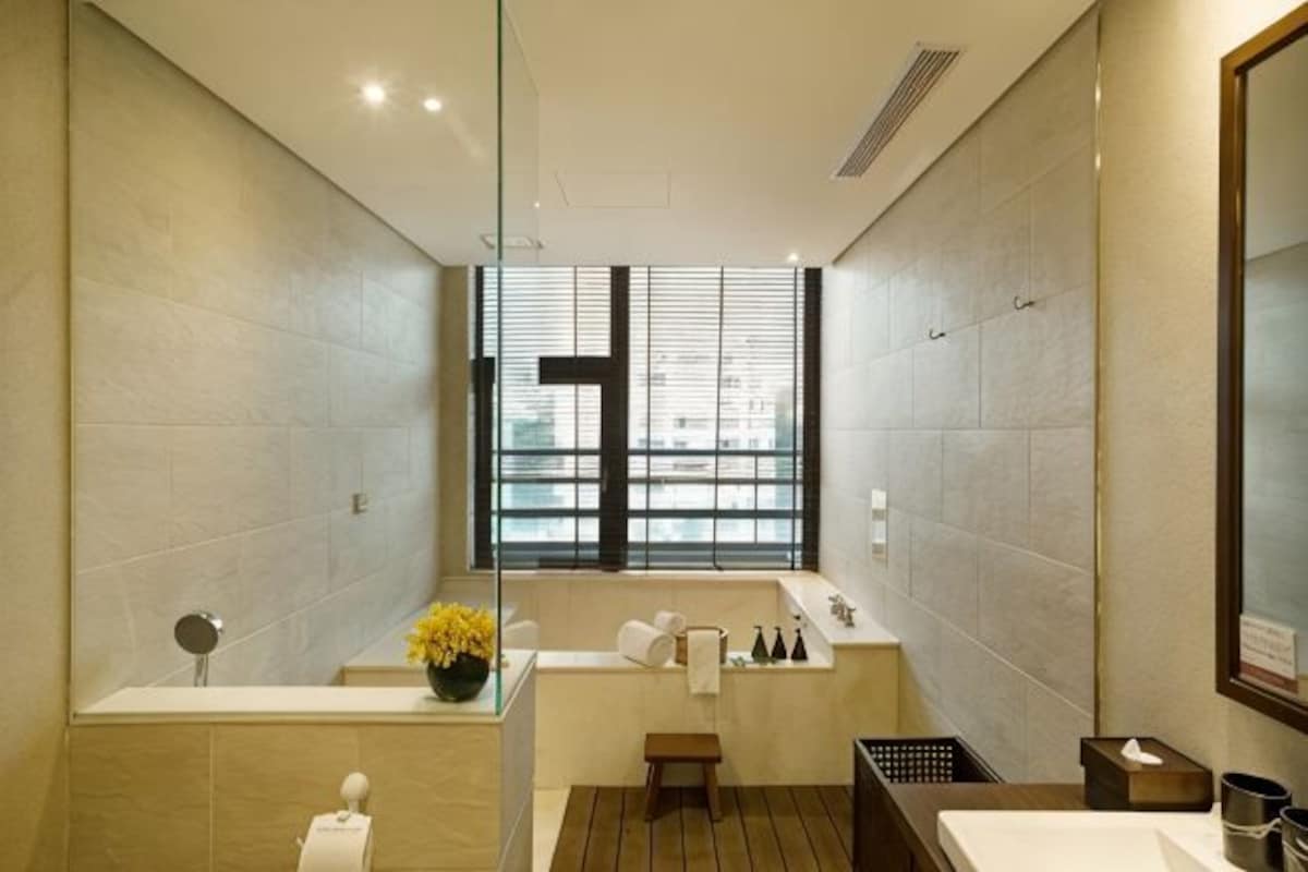 Un bagno moderno con una vasca, una finestra e uno specchio.
