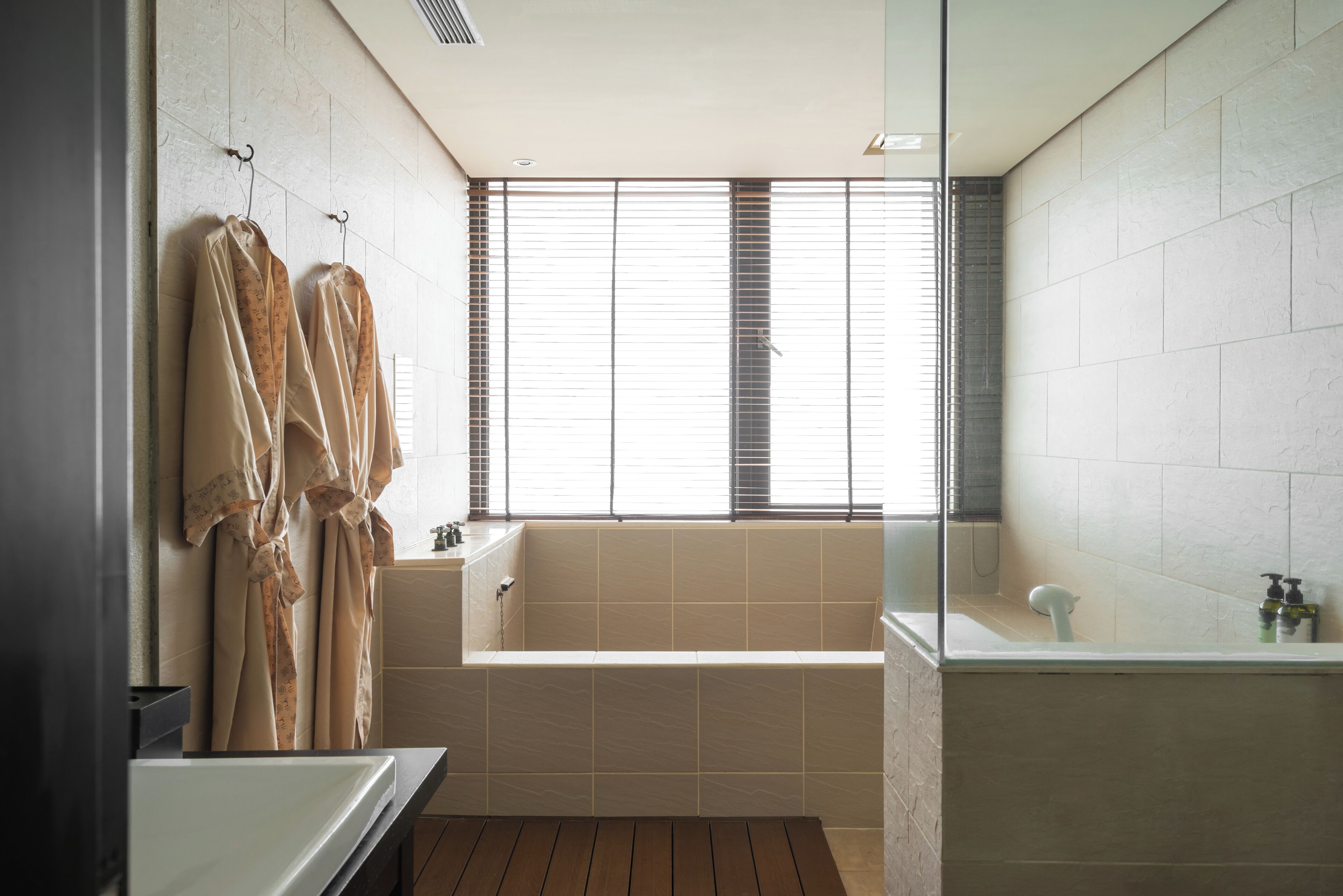 A modern bathroom with a freestanding bathtub, a glass shower enclosure, and a vanity with a mirror.