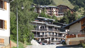 Eine Bergstadt mit Häusern, einer Straße und einem Berg im Hintergrund.