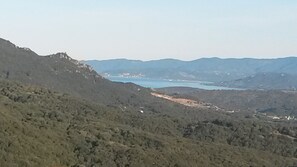 A mountainous landscape with a valley and a body of water.