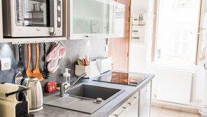 A modern kitchen with a built-in microwave, a large window, and a sink.