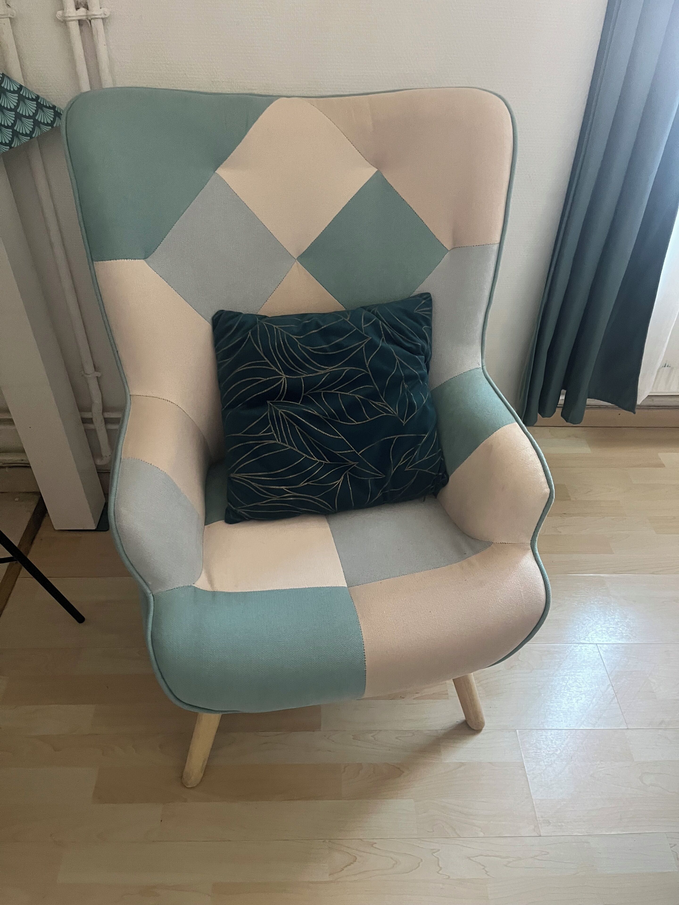 Una silla con diseño patchwork y un cojín estampado con motivos de hojas.