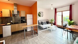 A modern kitchen with a dining area, a sofa, and a view of the outdoors. - Quiet Salagou cottage with lovely view over the valley (Octon)