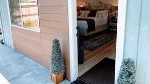 Une chambre à coucher avec un lit, des tables de chevet et une commode. Il y a une fenêtre sur le côté gauche de la pièce.