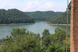 A view of a river surrounded by dense forest and hills.