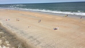 A beach with people sunbathing and walking. - OCEANVIEW TOPSAIL ISLAND BEACH CONDO  1BR 1BA  KING BED SNOWBIRD FRIENDLY (North Topsail Beach)
