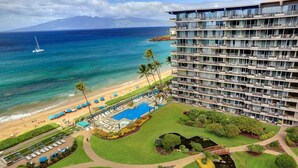 A hotel with a pool, beach, and ocean view.