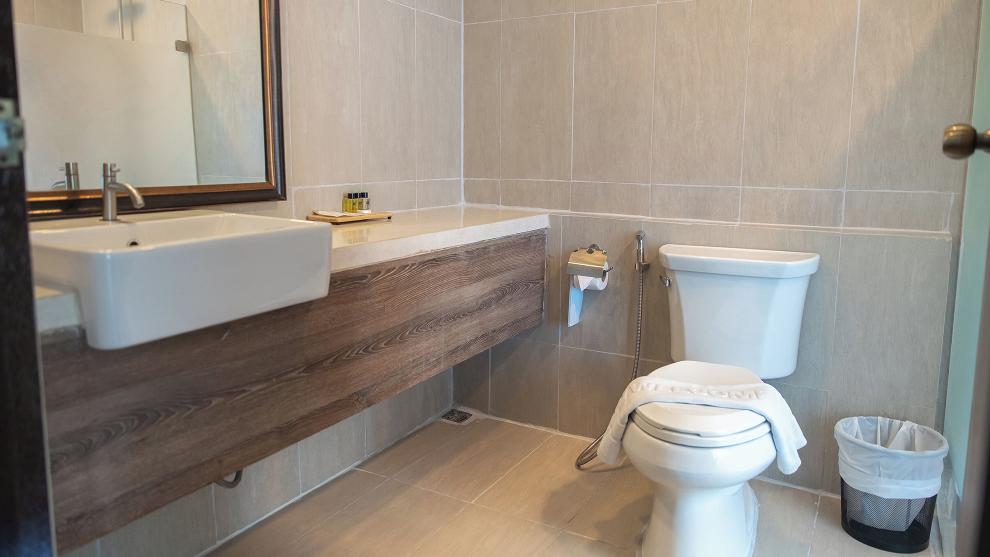 A bathroom with a sink, mirror, toilet, and shower.