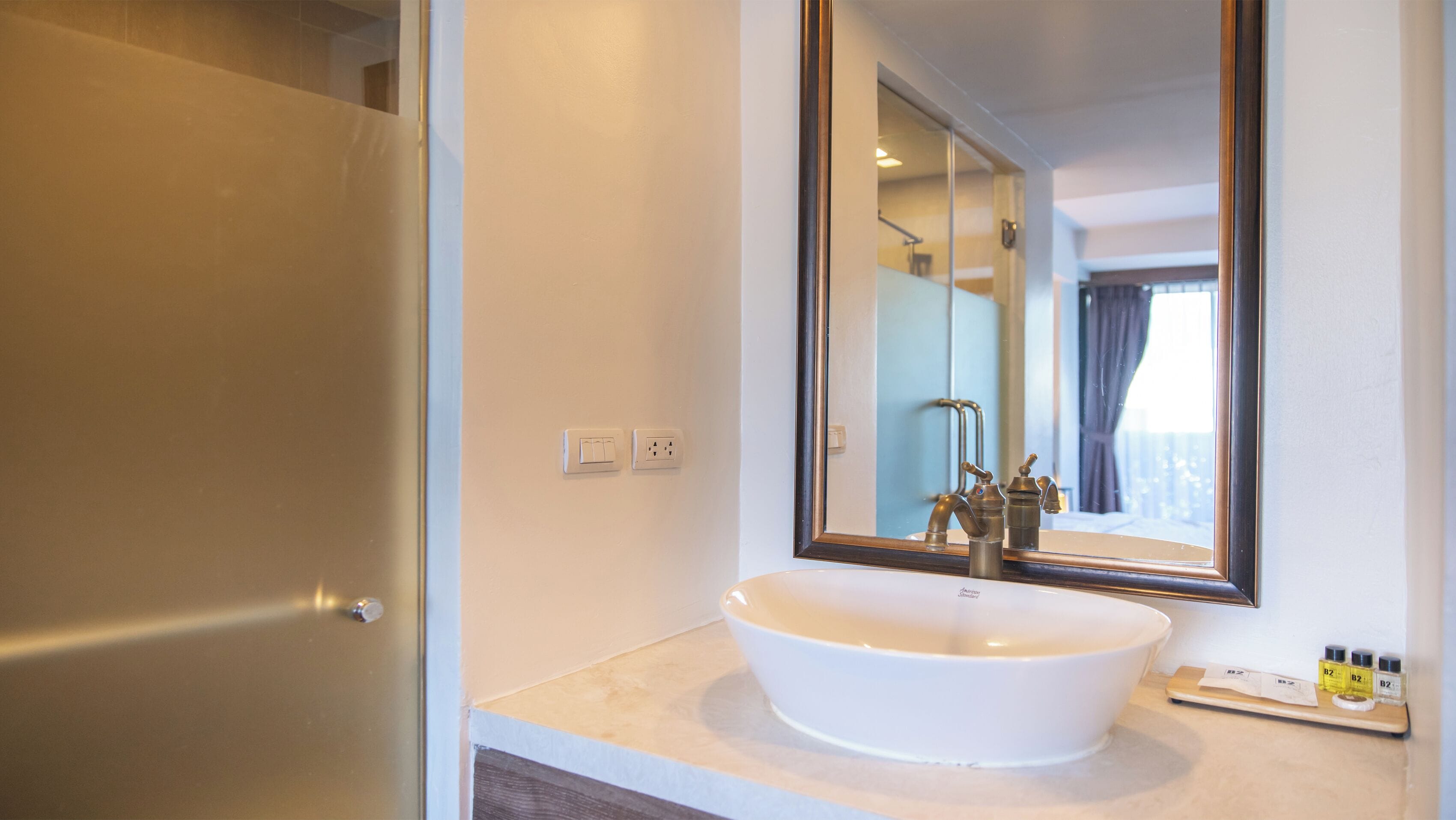 A bathroom with a white sink, a mirror, and a shower door.