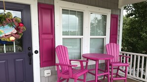 A porch with a purple door, two pink Adirondack chairs, and a small table. - Beautiful newer home! 2 blocks to the boardwalk & 3 blocks to the beach!!!! (CAROLINA BEACH)