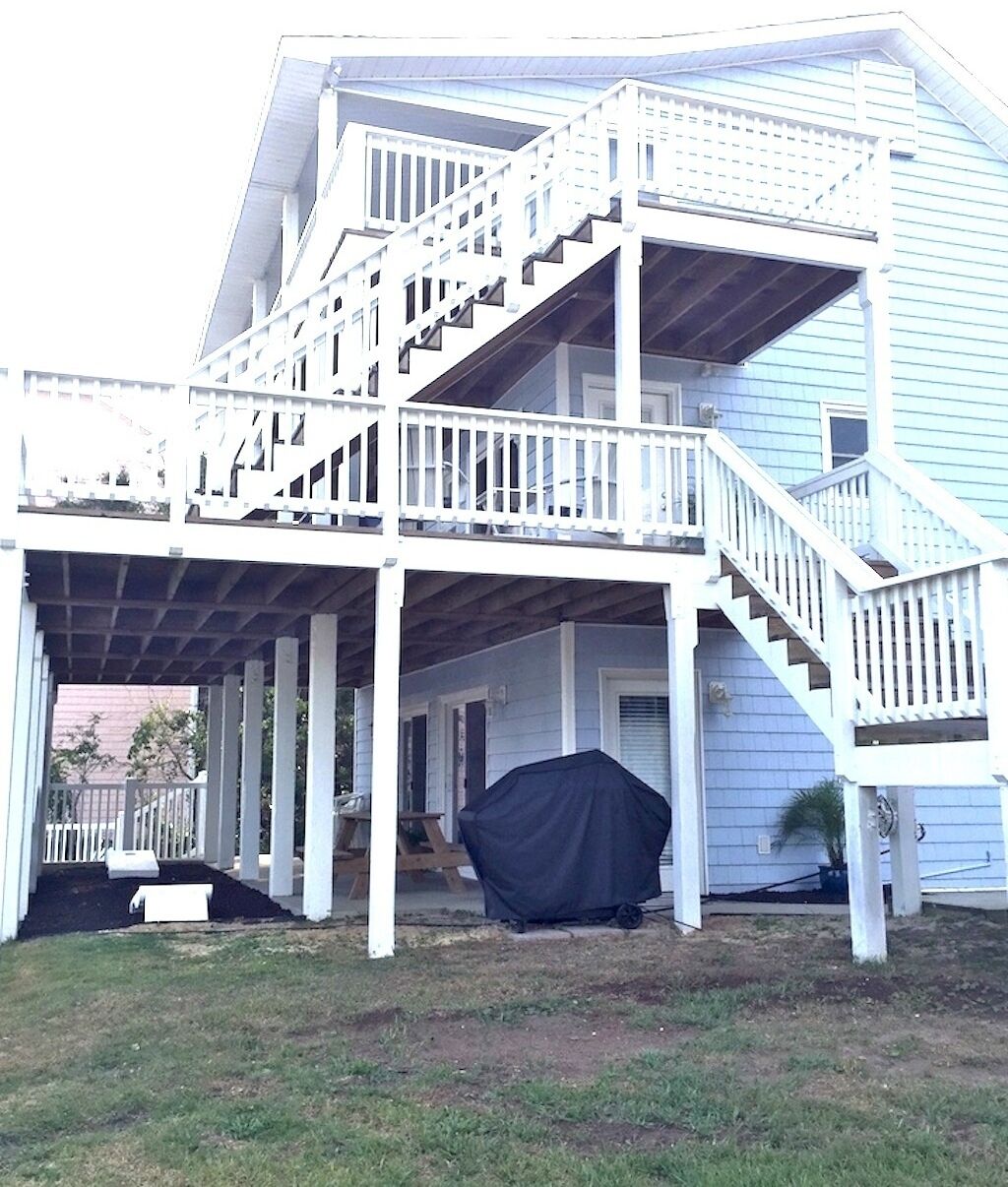 A two-story house with a covered porch and a staircase leading to the upper floor.