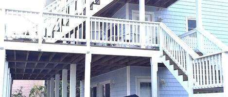 A two-story house with a covered porch and a staircase leading to the upper floor.