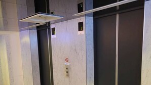 A modern elevator with digital displays and a no-smoking sign. - Attic Hotel (Taipei)