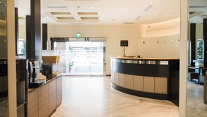 A hotel reception area with a marble floor, a reception desk, and a view of the outside through a glass door. - Kaohsiung The Rivero Hotel (Kaohsiung)