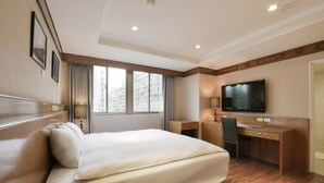 A hotel room with a bed, desk, chair, and a TV on the wall. - Kaohsiung The Rivero Hotel (Kaohsiung)