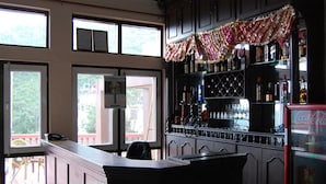 Un espace bar avec un comptoir, des étagères remplies de bouteilles et un réfrigérateur.