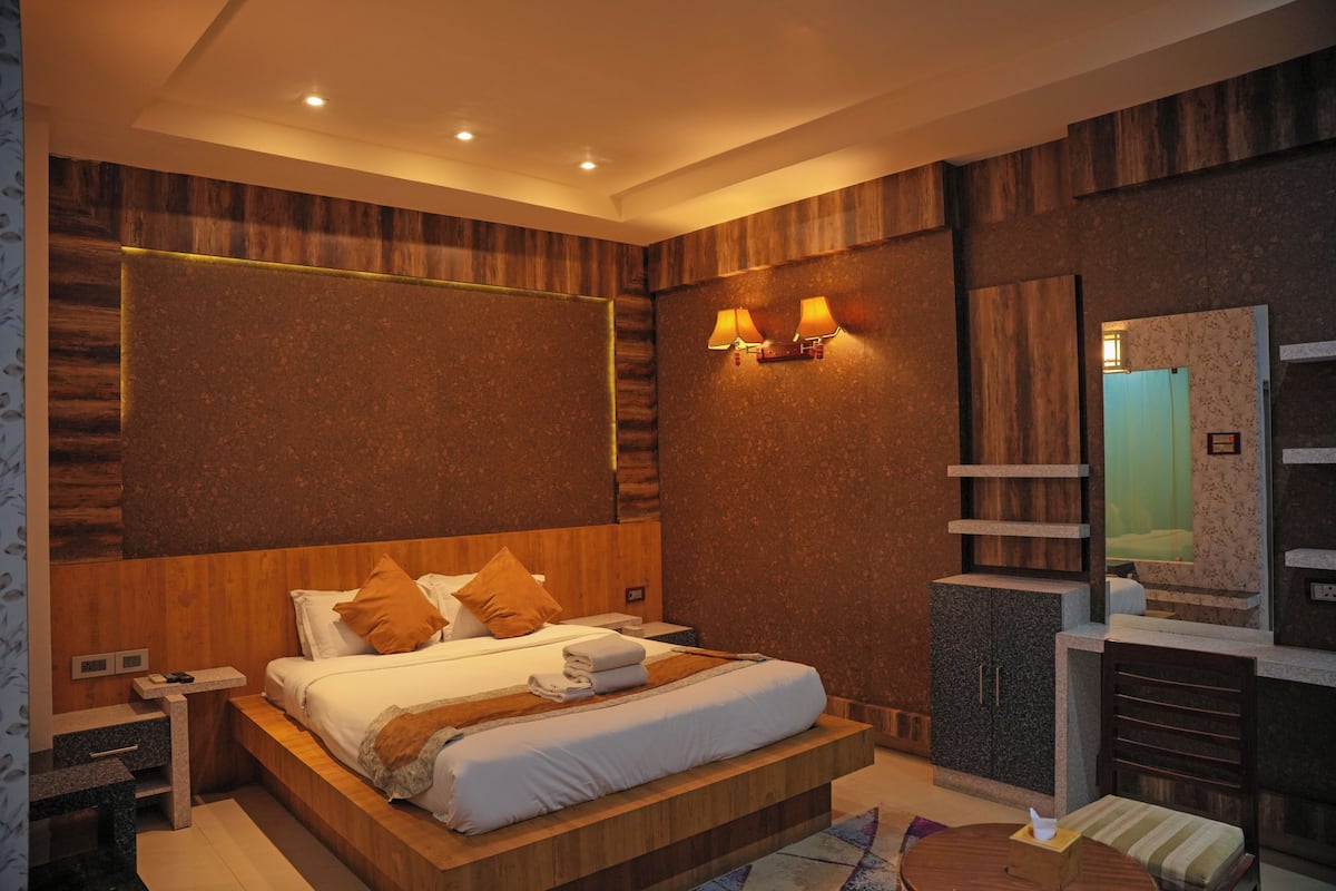 Ein modernes Schlafzimmer mit einem großen Bett, einem Holzkopfbrett und eingebauten Regalen.