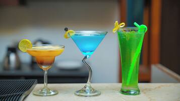 Three cocktails on a marble table with a blurred background.