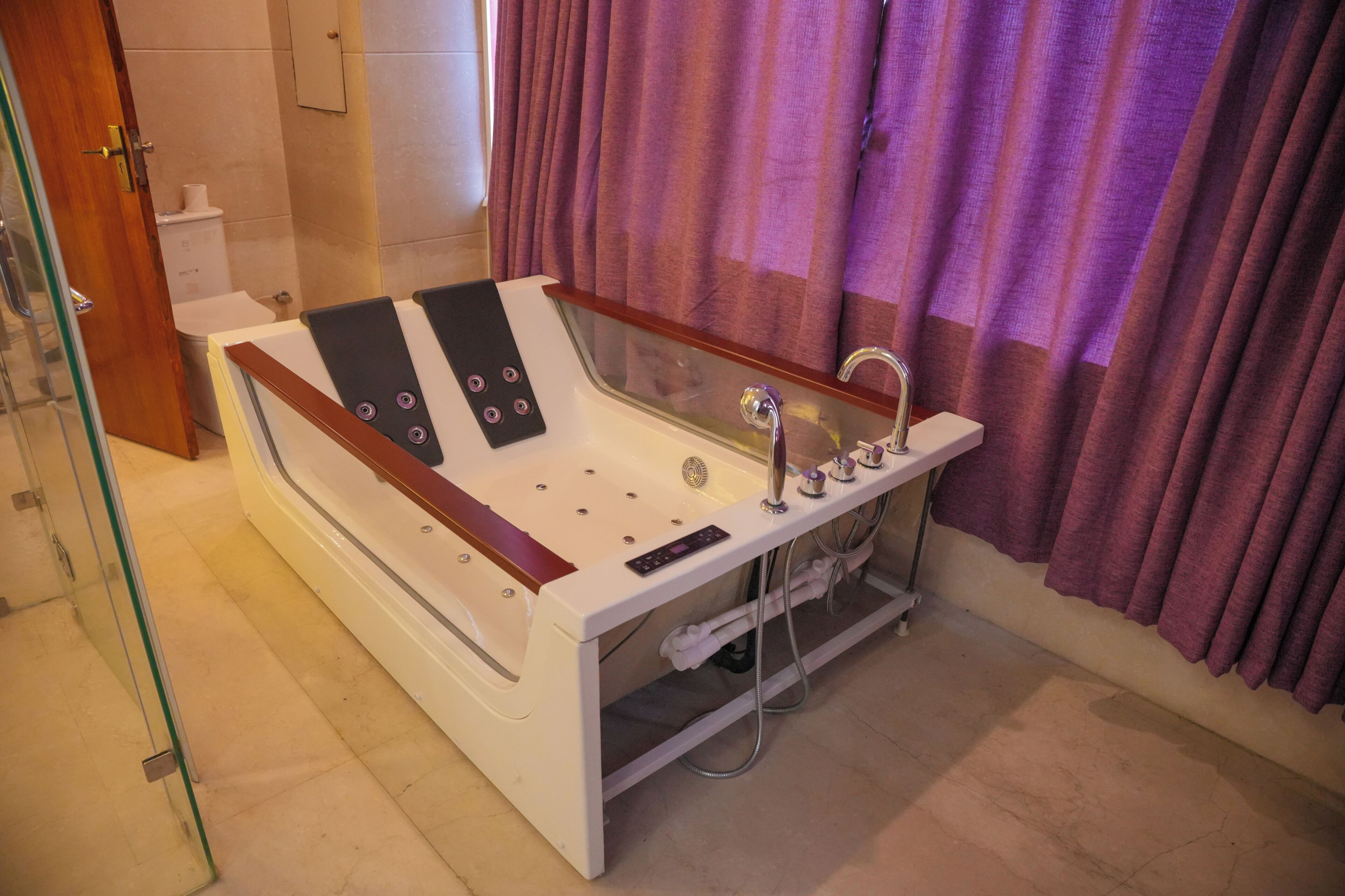 Un baño moderno con una bañera grande, un cabezal de ducha de mano y un panel de control.