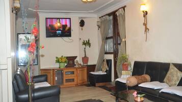 Habitación Deluxe | Área de sala de estar | Televisión