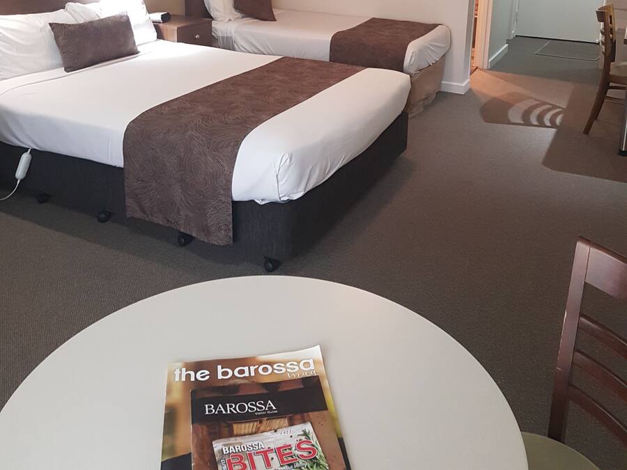 Une chambre d’hôtel avec deux lits, un ventilateur de plafond, une table et une chaise.