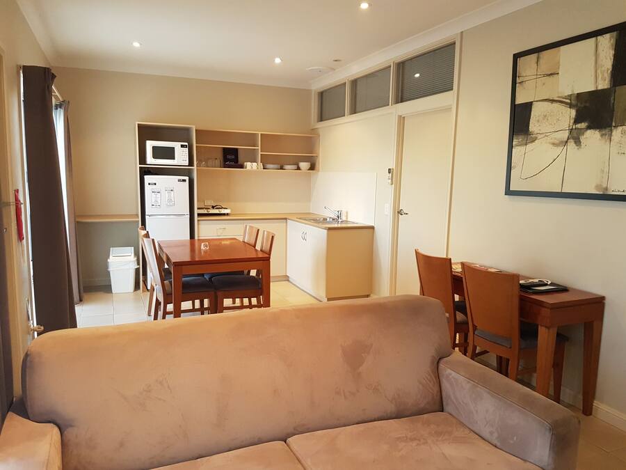 A compact living space with a kitchenette, a dining area, and a sofa.