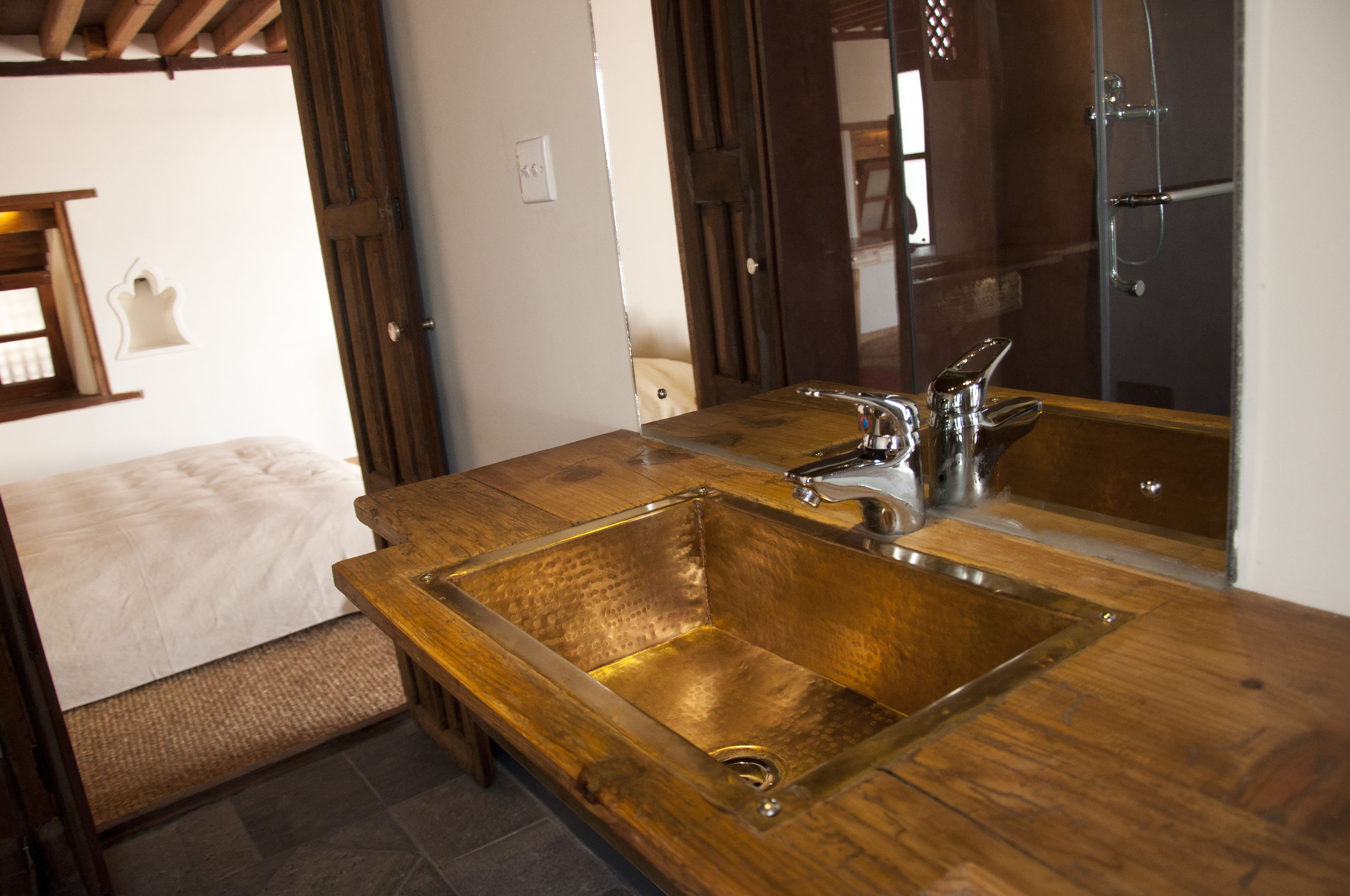 A bathroom with a wooden vanity, a double sink, and a mirror.