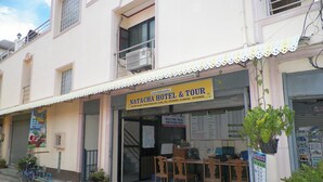 A hotel named Natacha Hotel & Tour with a visible reception area, a staircase leading to the upper floor, and a small outdoor seating area. - Natacha Hotel (Ko Phi Phi)