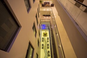 A high-ceilinged interior with a central water feature, seating area, and a view of the outside. - Yatri Suites and Spa (Kathmandu)