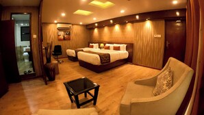 Ein Hotelzimmer mit einem großen Bett, zwei Nachttischen, einem Sofa, einem kleinen Tisch und einem Spiegel.