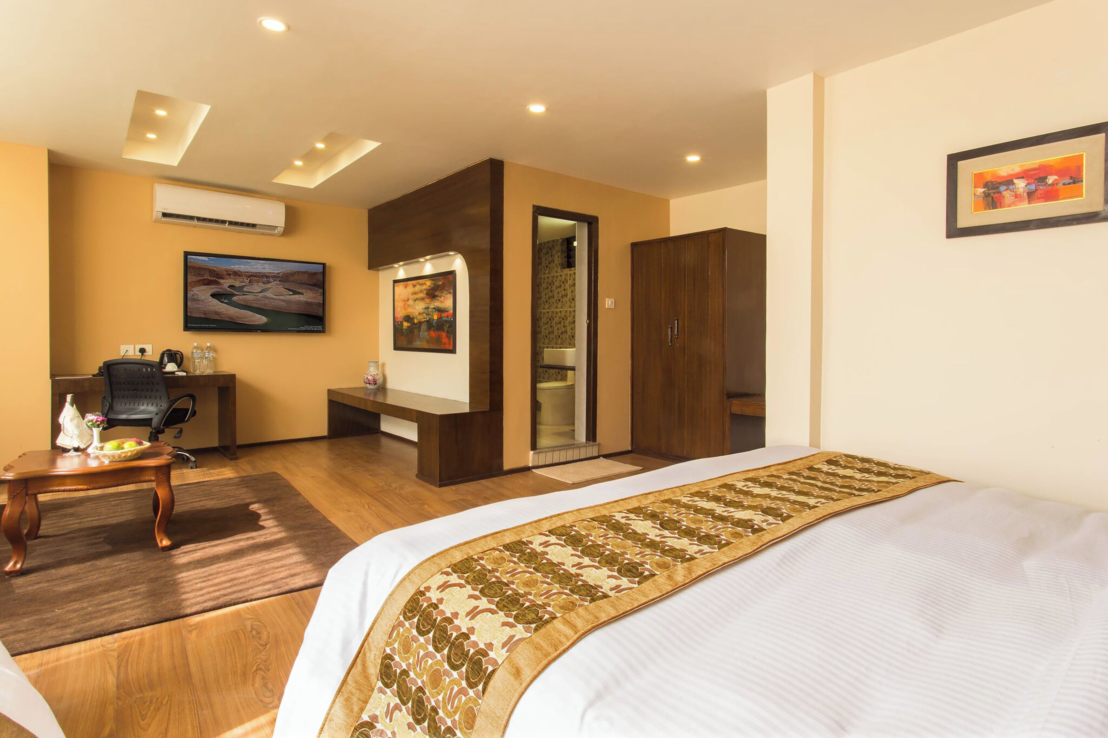 Ein Hotelzimmer mit Bett, Schreibtisch, Stuhl, Kleiderschrank und Bad.