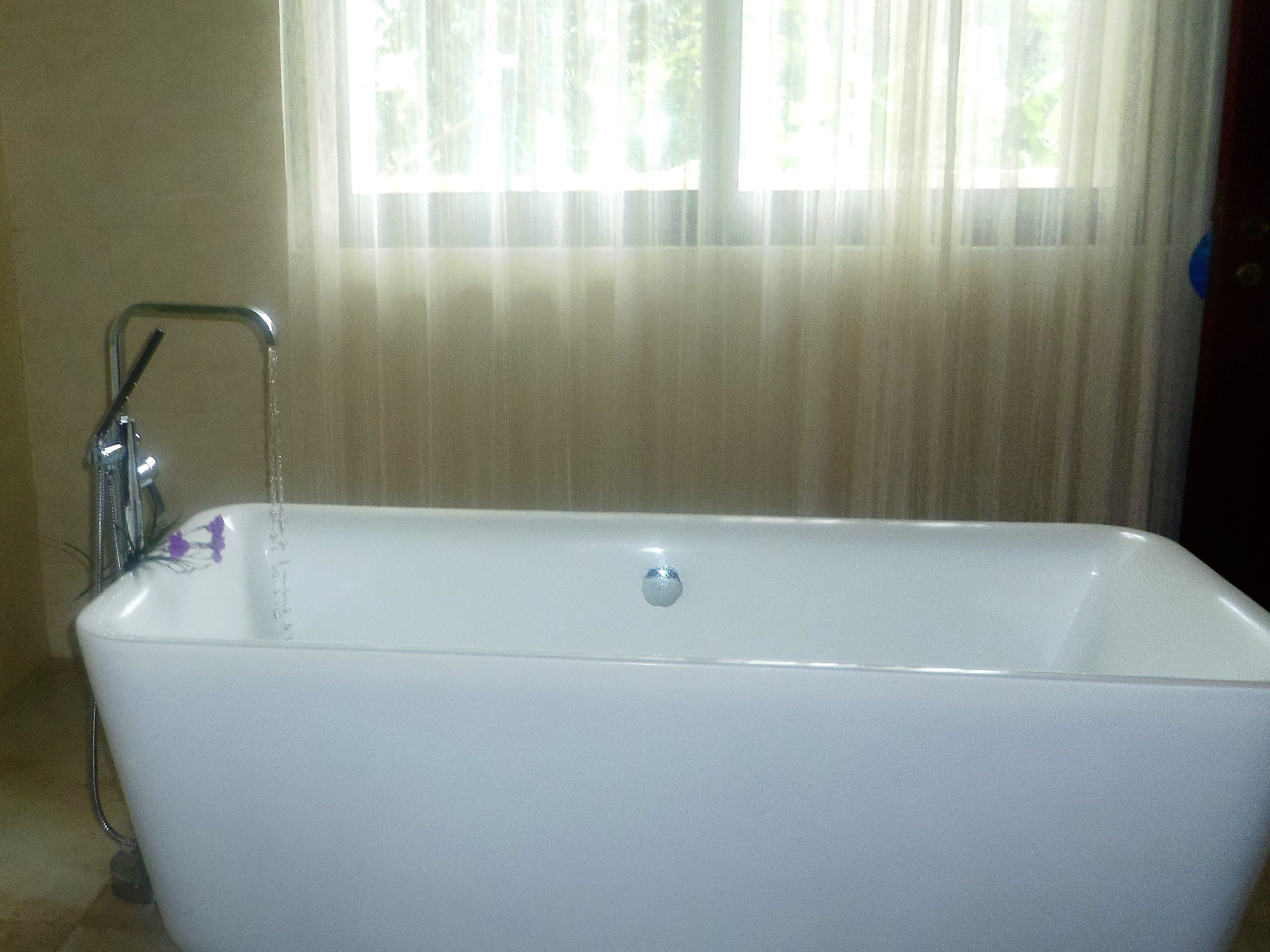 Una bañera blanca con grifo y desagüe.