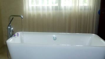 Una bañera blanca con grifo y desagüe.