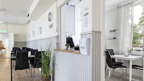 A reception area with a white counter, a clock, and a sign that reads "POST". - Alkoven Logi (Ullared)