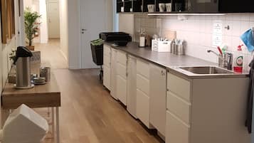 Una cocina moderna con armarios blancos, un lavamanos de acero inoxidable y una encimera negra.