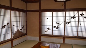 A traditional Japanese room with tatami flooring, shoji screens, and a low wooden table with a bowl and chopsticks. - Homeikan Morikawa Annex (Tokyo)