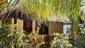 Una costruzione con tetto di paglia immersa in una rigogliosa vegetazione tropicale.