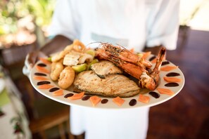 A plate of food including shrimp, chicken, and vegetables. - Maisha Nungwi (Nungwi)