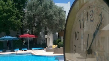 Piscina externa, piscina com cascata, guarda-sóis, espreguiçadeiras