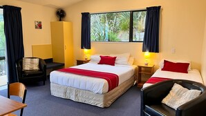 A hotel room with two beds, a desk, a chair, and a wardrobe. - Sundowner Motel (Greymouth)