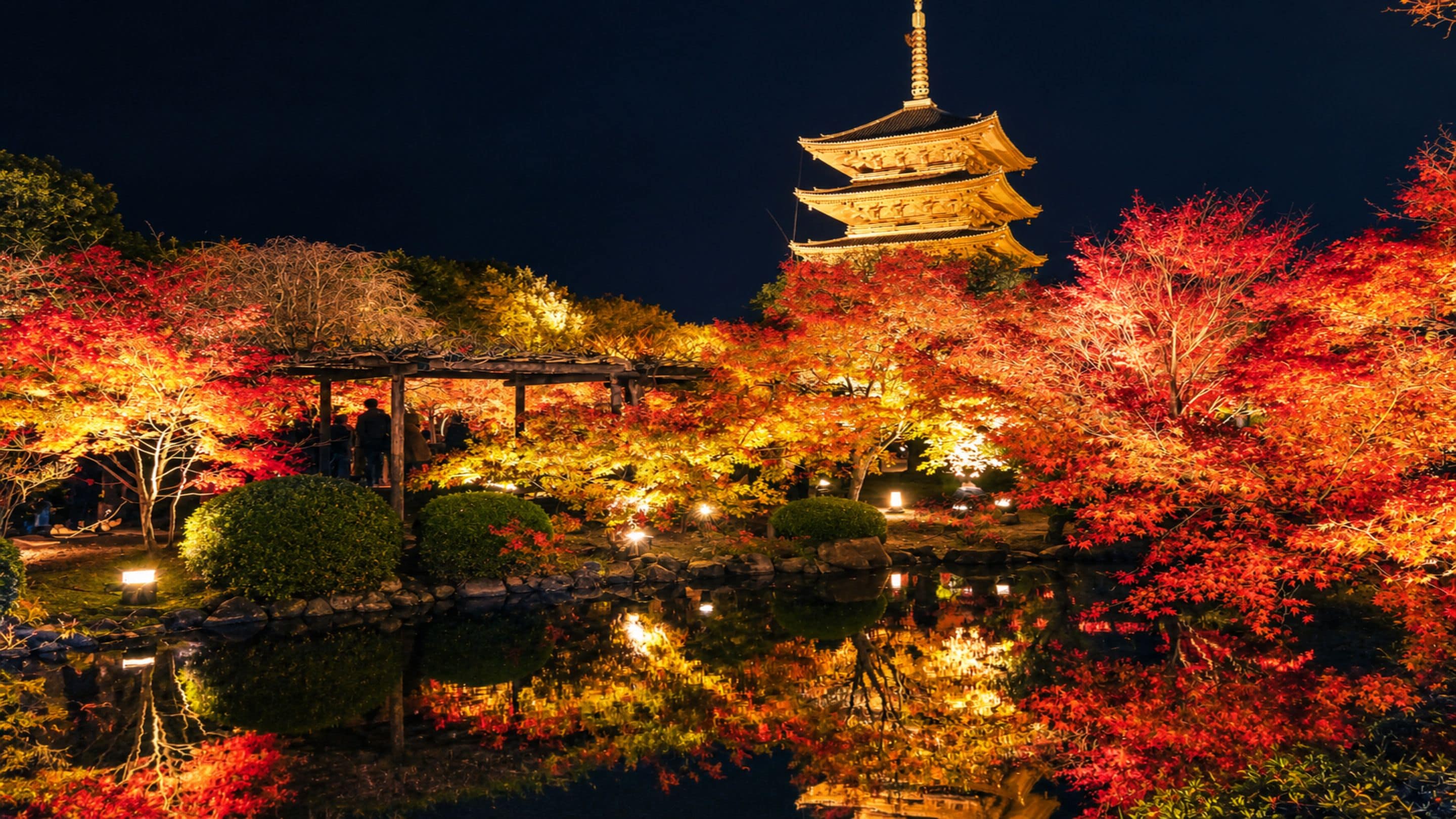 A traditional Japanese pagoda with a reflection in a pond, surrounded by autumn-colored foliage.