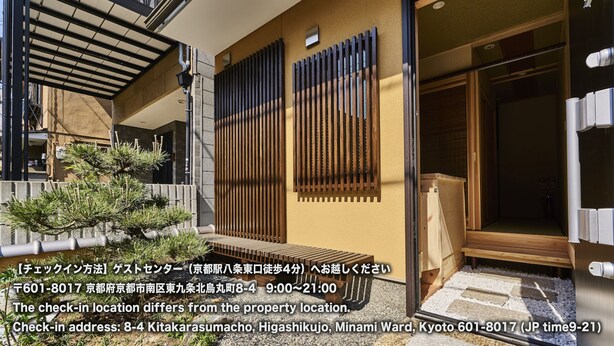 Ein traditionelles japanisches Gebäude mit Holzfassade, einer Schiebetür und einem kleinen Garten mit einer Kiefer.