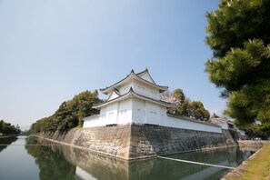 A traditional Japanese castle with a stone base and white walls, surrounded by a moat and trees. - Stay SAKURA Kyoto Nijo Castle West I (Kyoto)