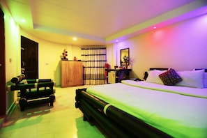 Relax in this serene space with a large bed, a comfortable bench, and a convenient desk area.