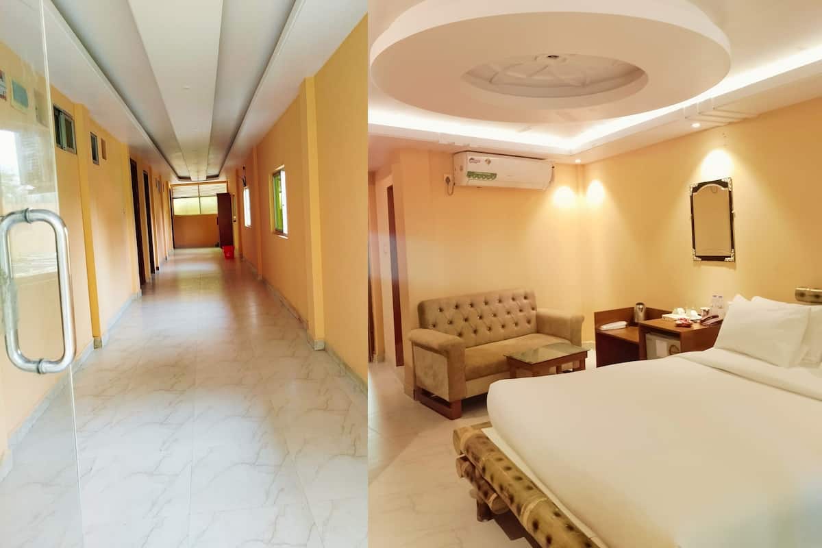 Un pasillo de hotel con rampa para silla de ruedas, un sofá, una mesita de noche y una cama.