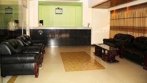 A lobby with leather sofas, a reception desk, and a coffee table. - Cox's Hilton (Cox's Bazar)